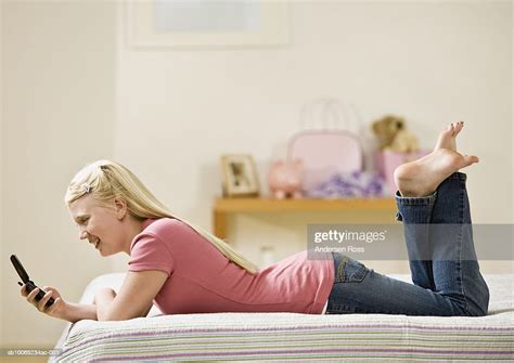 Teenage Girl Texting Using Cell Phone On Bed Photo Getty Images