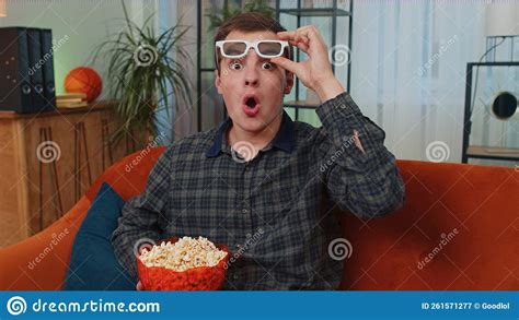 Man Sitting On Couch Eating Popcorn And Watching Interesting Tv Serial