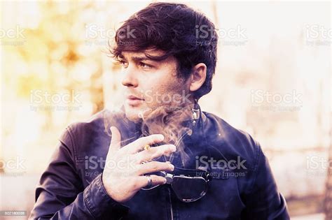 Young Biker Relaxing Smoking A Cigarette Stock Photo Download Image