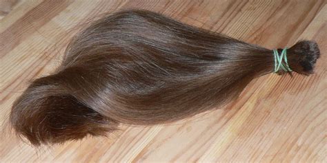 Holding your hair firmly up above your head, cut into it with scissors. Recycler les cheveux pour sauver l'environnement