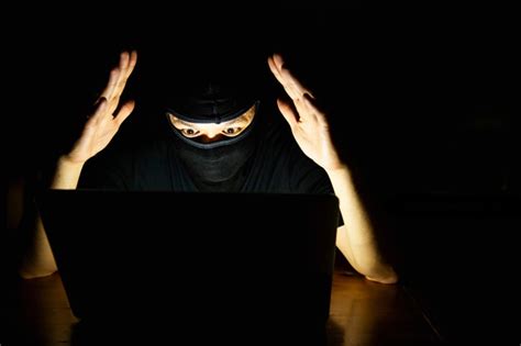 Hacker de computador fazendo seu trabalho com o computador portátil no quarto escuro | Foto Grátis