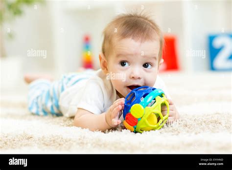 Baby Lying On Soft Carpet In Children Room Stock Photo Alamy