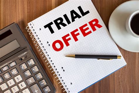 Trial Offer Written In A White Notepad Near A Calculator And A Cup Of