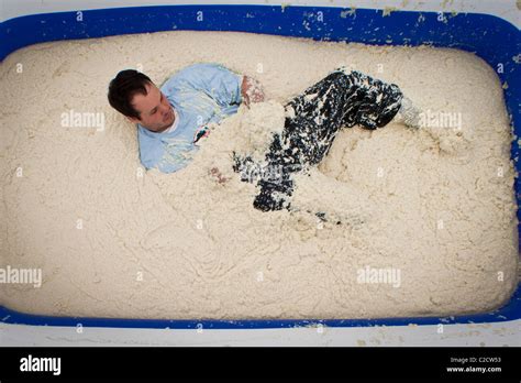 A Participant In The Grits Roll Wallows In A Pool Of Grits During The Annual World Grits