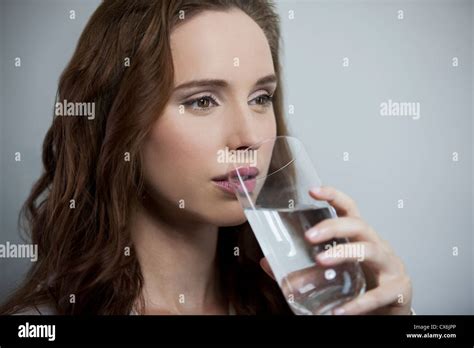 A Young Brunette Woman Drinking A Glass Of Water Stock Photo Alamy