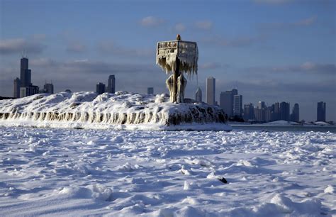A Harbor Light Is Covered By Snow And Ice On The Lake Michigan At 31st