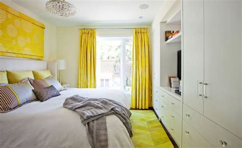 A Bed Room With A Neatly Made Bed And Yellow Curtains