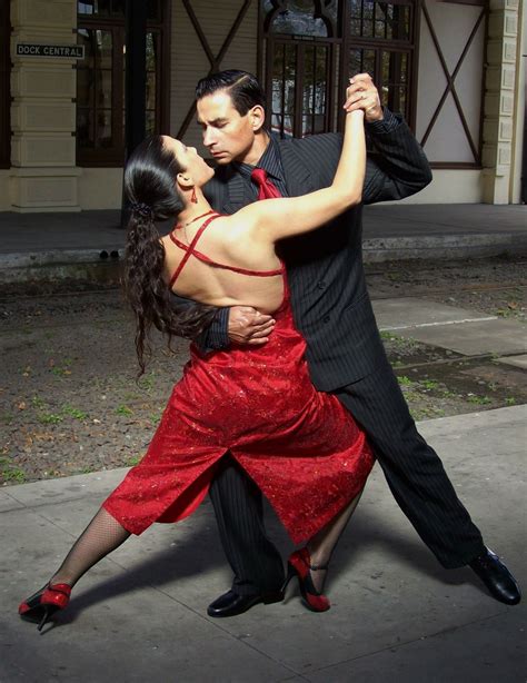 A Man And Woman Are Dancing On The Street