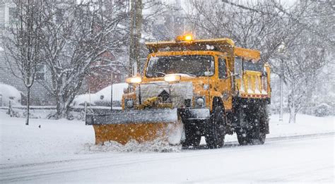 Yellow Snowplow Clearing A Road During A Snow Storm Stock Image Image