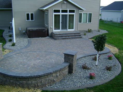 Earth Tone Paver Patio With Sitting Wall And Rock Fill Edging Oasis