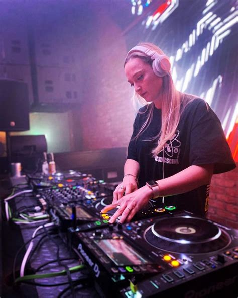 A Woman In Headphones Is Playing Music On A Djs Turntable At A Party