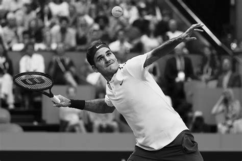 A Man Swinging A Tennis Racquet At A Ball In Front Of A Crowd