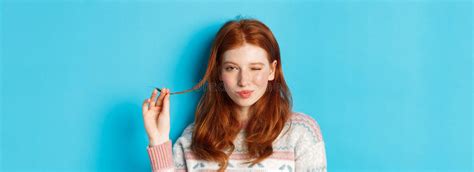 Close Up Of Cheeky Redhead Girl Playing With Hair Strand Winking And