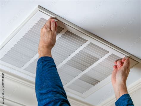 Man Opening Ceiling Air Vent To Replace Dirty Hvac Air Filter Home Air