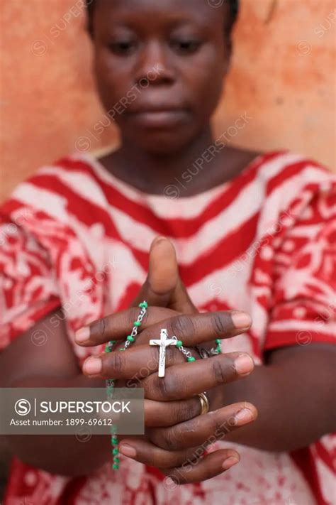 African woman praying the rosary. - SuperStock