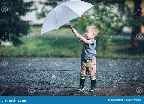 Adorable Child Holding an Umbrella in a Rain Storm Stock Photo - Image