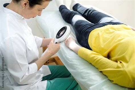Dermatologist Using A Professional Magnifying Glass While Doing Skin