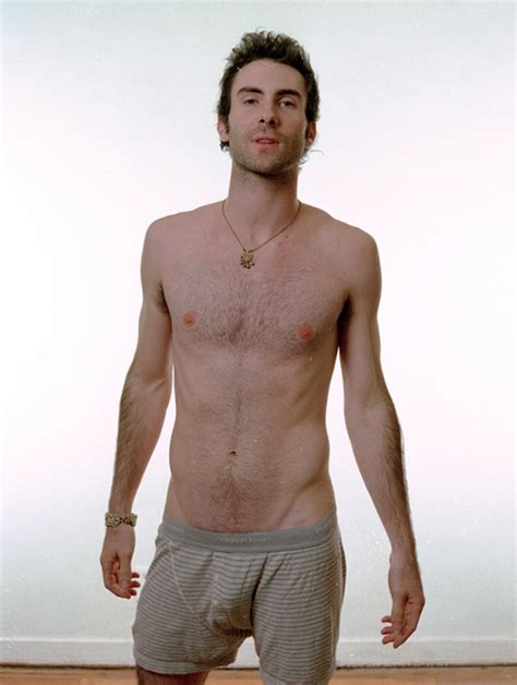 A Man Without A Shirt Standing In Front Of A White Wall