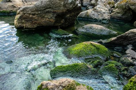 Rock Covered With Moss On The Green Mountain River Bank Stock Photo