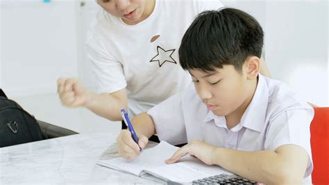 Slow Motion Of Asian Mother Helping Her Son Doing Homework On White