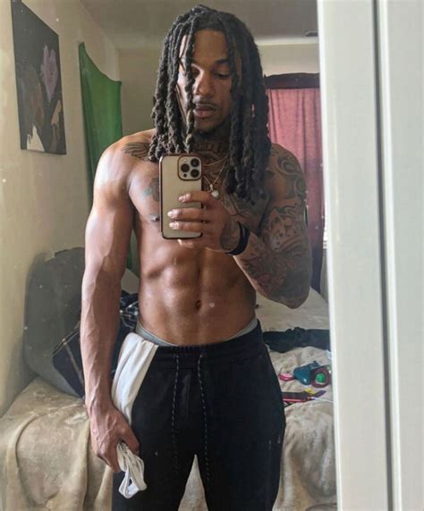 A Man With Dreadlocks Taking A Selfie In His Bedroom While Wearing