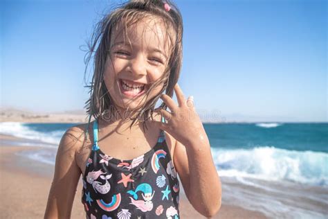 Portrait Of A Cheerful Little Girl In A Bathing Suit By The Sea Stock