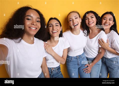 Five Multiracial Girls Making Selfie Posing Standing Over Yellow