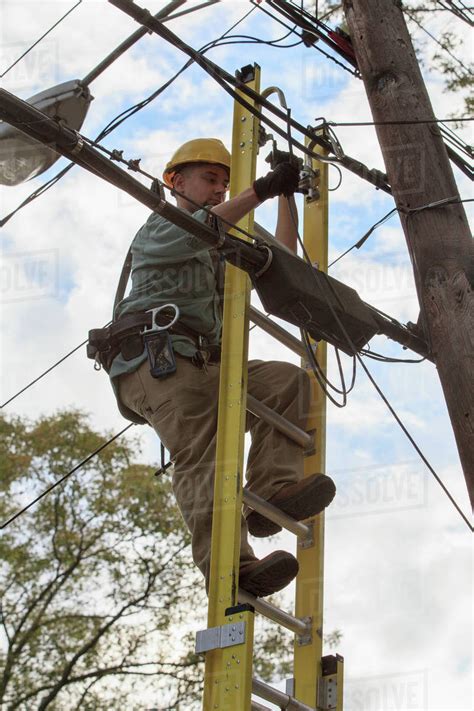 Caucasian Cable Installer Working On Ladder Stock Photo Dissolve
