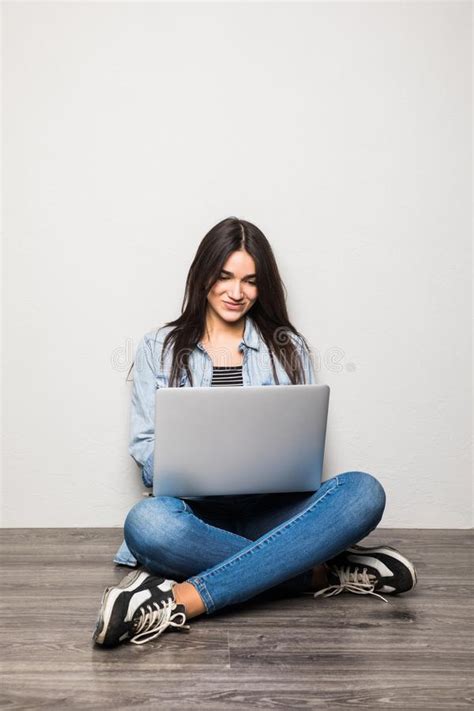 Happy Young Woman Sitting On The Floor With Crossed Legs And Using