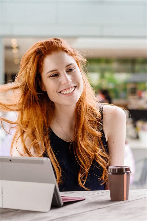 beautiful redhead using computer in cafe by stocksy contributor gillian vann stocksy