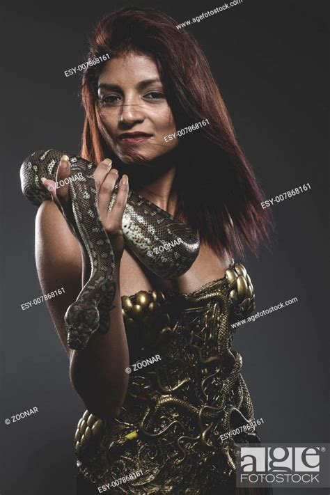 Sensual Tattooed Woman With Big Snake And Iron Corset Stock Photo