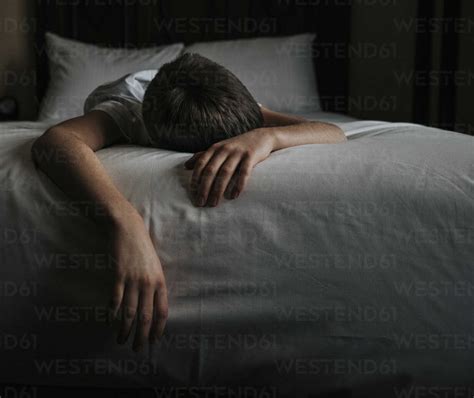 Boy Sleeping On Bed At Home Stock Photo