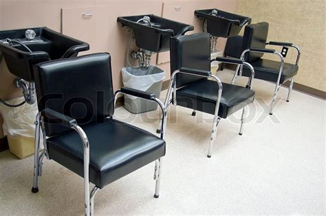 A salon employee washes hair to woman in the sink. Hair Salon - a row of hair washing ... | Stock image ...