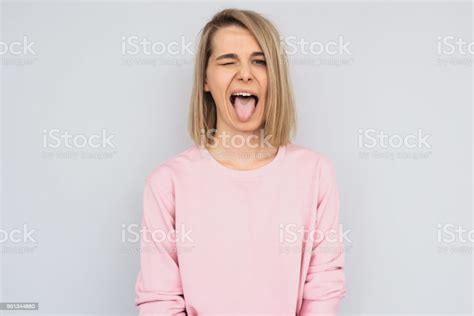 Portrait Of Disgusted Pretty Female Sticking Out Tongue Expressing Her Disagreement To Something