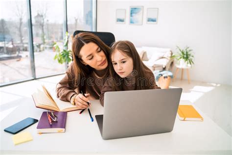 Mamá Y La Pequeña Hija Haciendo La Tarea En La Computadora Portátil