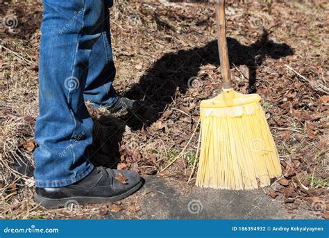 Sweeping Dry Leaves With Yellow Plastic Broom Close Up View Stock