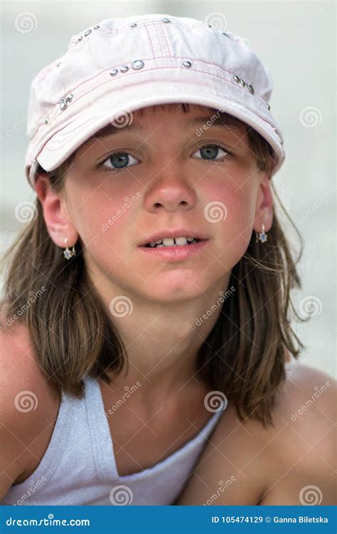 portrait of a cute tanned girl with big beautiful eyes in a cap on a summer vacation stock