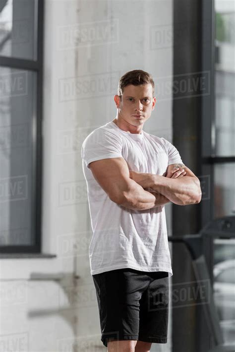 Handsome Athletic Bodybuilder Standing With Crossed Arms And Looking At