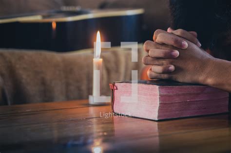 Praying Hands And Bible With Candle — Photo — Lightstock
