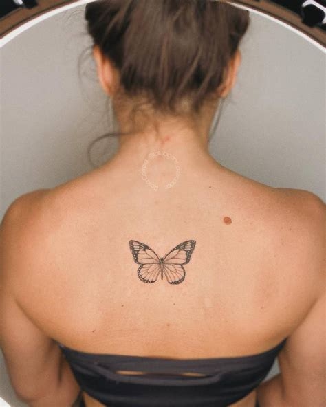 Fine Line Butterfly Tattoo Located On The Upper Back