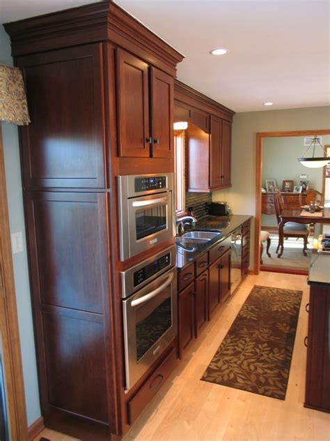 A pantry cabinet is sandwiched between the paneled refrigerator and a corner microwave/oven cabinet. Creating an Open Kitchen in Carmel - WrightWorks LLC ...