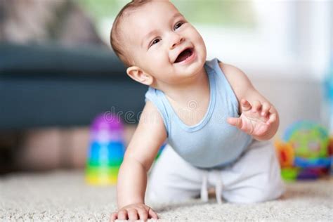 Cute Smiling Baby Boy Crawling On Floor In Living Room Stock Image