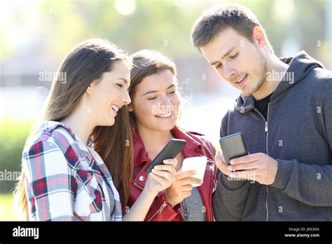 Three Friends Talking Together And Holding Everyone Their Smart Phones