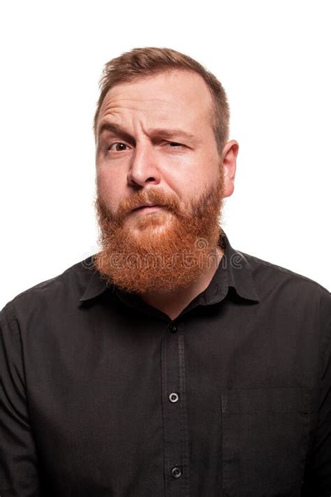 Portrait Of A Young Chubby Redheaded Man In A Black Shirt Making Faces At The Camera Isolated