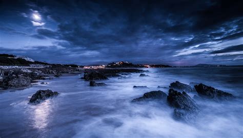 Landscape Photography Of Rocky Seaside Under Cloudy Sky During