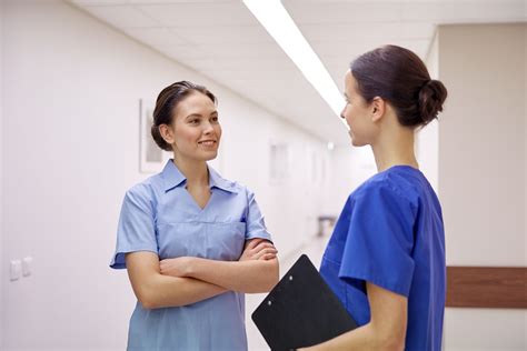 Many travel nursing agencies offer health insurance to their nurses. Two nurses communicate | Ameritech College of Healthcare