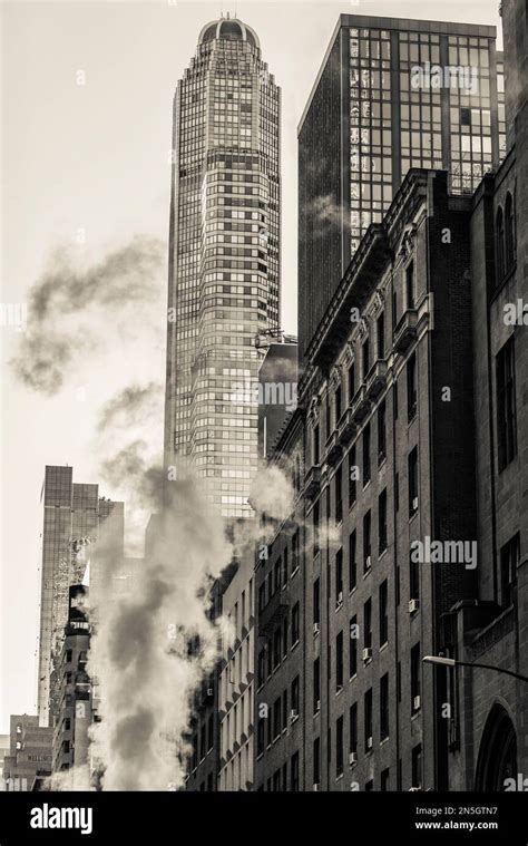 Smoke From Underground Heating Rising Up In A Street In Midtown