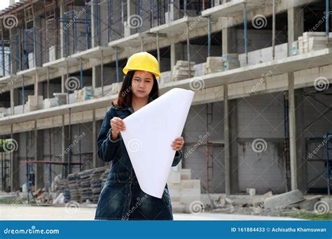 Female Civil Engineer Or Architect With Yellow Helmet Standing With