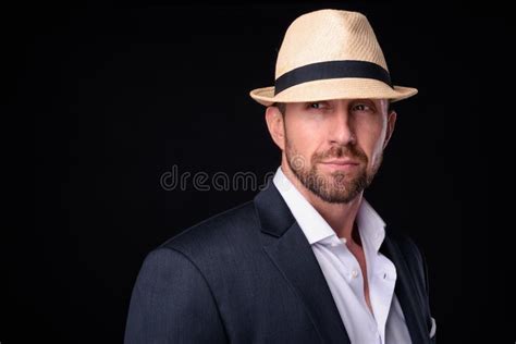Portrait Of Handsome Bearded Businessman In Suit Wearing Hat Stock