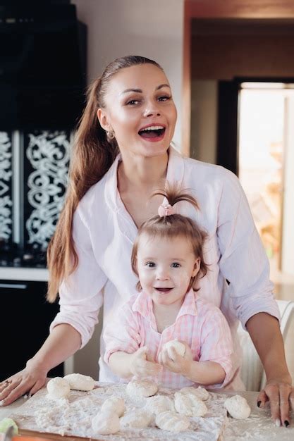 Premium Photo Beautiful Loving Mother And Pretty Daughter Cooking Together In The Kitchen